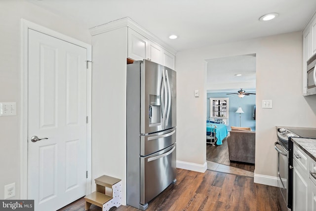 kitchen with ceiling fan, white cabinetry, appliances with stainless steel finishes, dark hardwood / wood-style floors, and light stone countertops