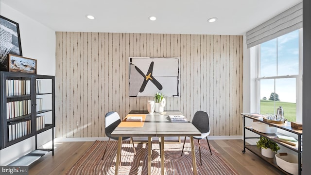 dining area featuring wood walls and hardwood / wood-style flooring