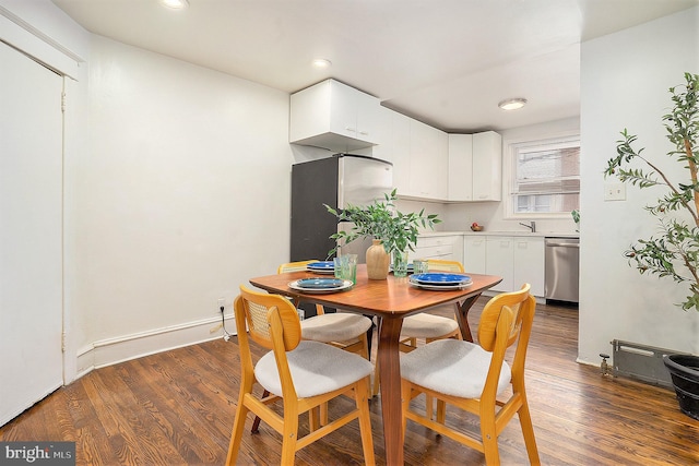 dining room featuring sink and dark wood-type flooring