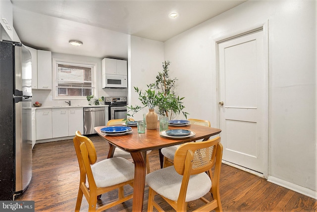 dining room with dark hardwood / wood-style flooring and sink