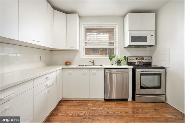 kitchen with appliances with stainless steel finishes, sink, and white cabinets