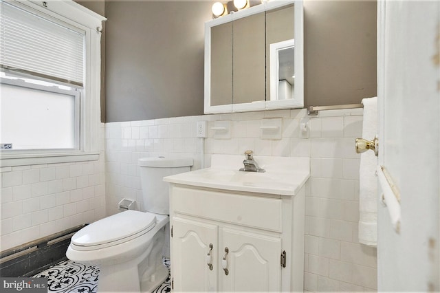 bathroom with tile walls, vanity, and toilet