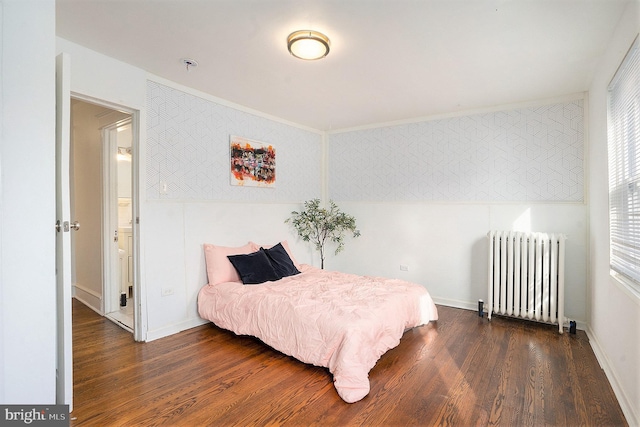 bedroom with dark hardwood / wood-style flooring and radiator