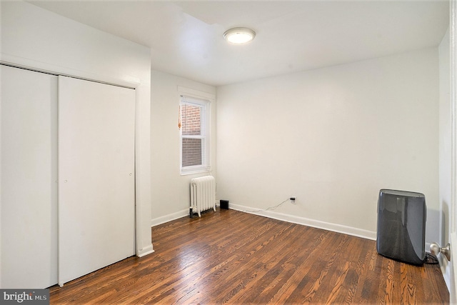 unfurnished bedroom with radiator, dark wood-type flooring, and a closet