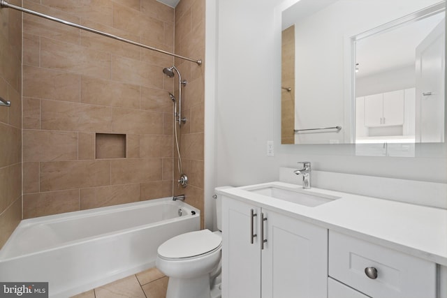 full bathroom with tile patterned flooring, tiled shower / bath, vanity, and toilet