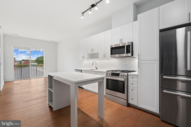 kitchen with stainless steel appliances, sink, dark hardwood / wood-style flooring, and white cabinetry