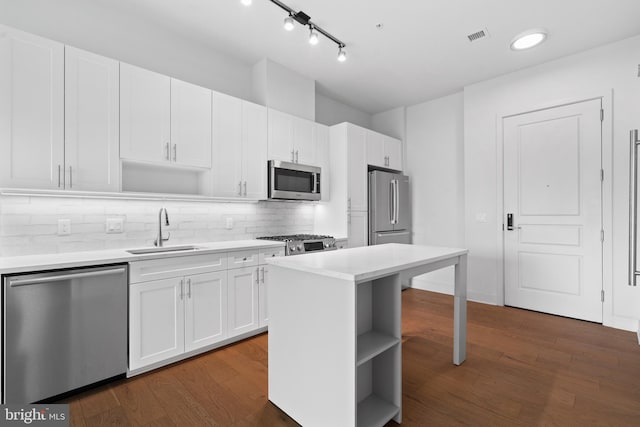 kitchen with white cabinetry, appliances with stainless steel finishes, dark hardwood / wood-style floors, and sink