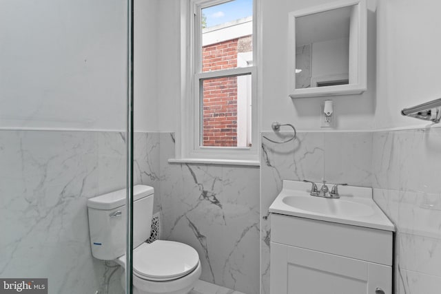 bathroom with tile walls, vanity, and toilet