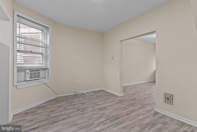 spare room featuring cooling unit and light hardwood / wood-style floors