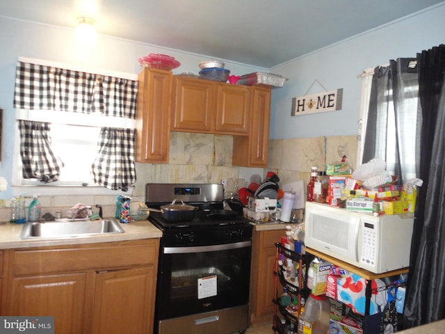 kitchen featuring stainless steel stove, backsplash, and sink