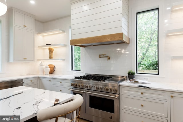 kitchen with appliances with stainless steel finishes, tasteful backsplash, custom range hood, and white cabinets