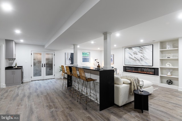 bar with french doors, white cabinets, and wood-type flooring