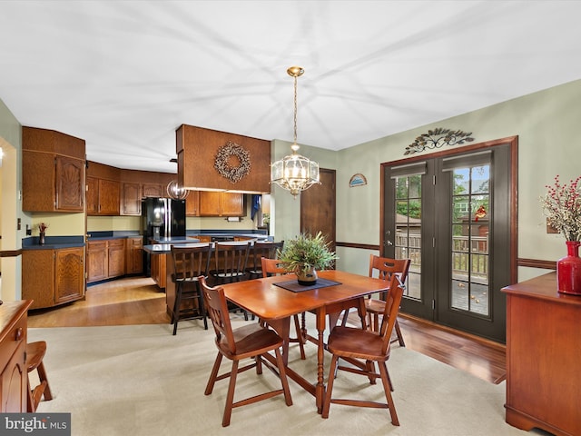 dining area with light hardwood / wood-style flooring and an inviting chandelier