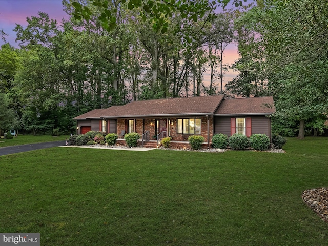 single story home with a lawn and covered porch