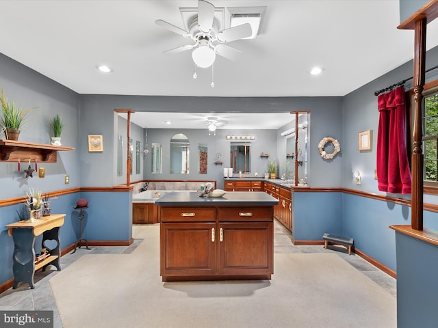 kitchen featuring ceiling fan, light colored carpet, and kitchen peninsula