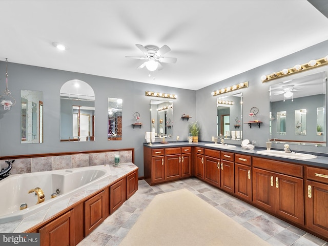 bathroom with a tub to relax in, vanity, and ceiling fan