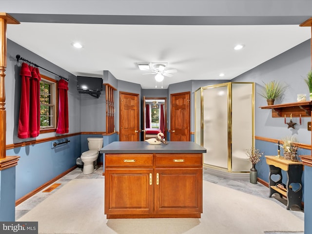 kitchen with a center island, ceiling fan, and light colored carpet