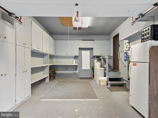 garage featuring water heater and white refrigerator