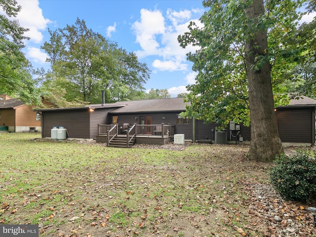 rear view of house with a deck, a yard, and central air condition unit