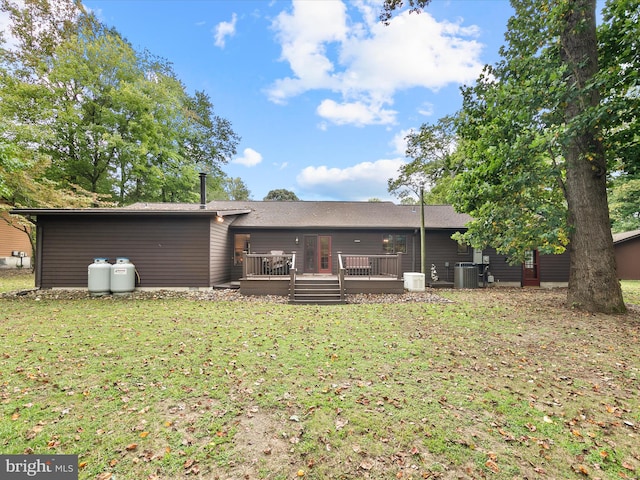 back of house featuring a wooden deck, a lawn, and central air condition unit