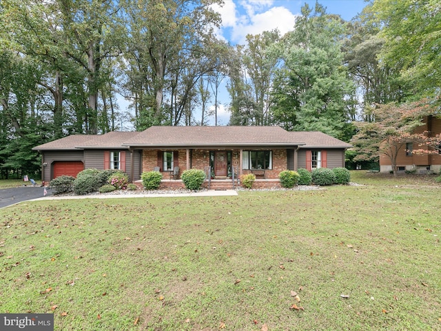 ranch-style home featuring a front lawn, covered porch, and a garage