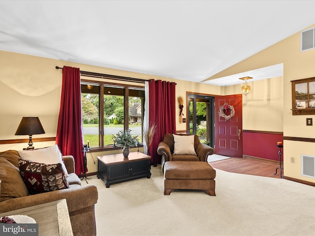 carpeted living room featuring vaulted ceiling