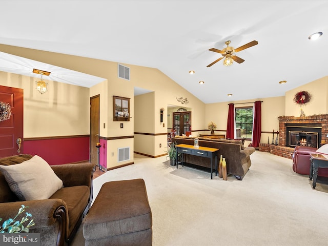 living room with light carpet, a fireplace, vaulted ceiling, and ceiling fan