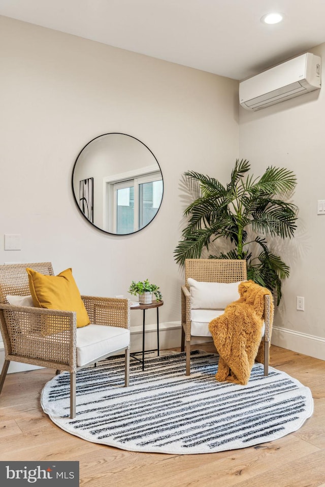 living area with wood-type flooring and a wall mounted AC