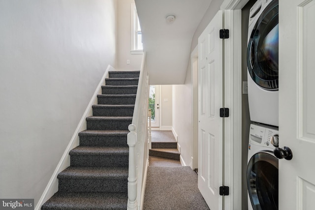 staircase featuring stacked washer / dryer and carpet