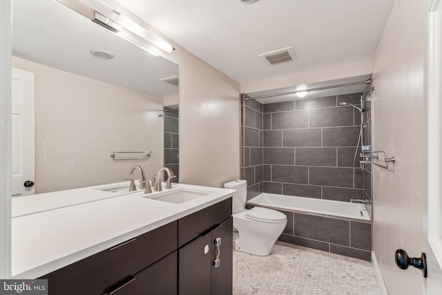 full bathroom with tiled shower / bath, vanity, toilet, and tile patterned floors