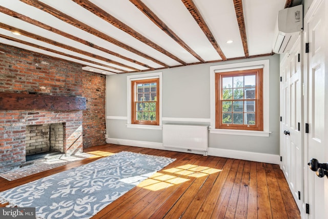 living room with hardwood / wood-style floors, radiator heating unit, brick wall, a fireplace, and a wall mounted AC