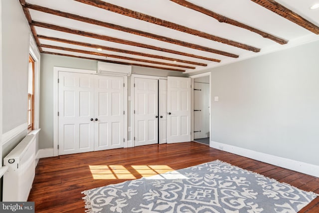 bedroom with beamed ceiling, a wall unit AC, dark hardwood / wood-style flooring, and radiator