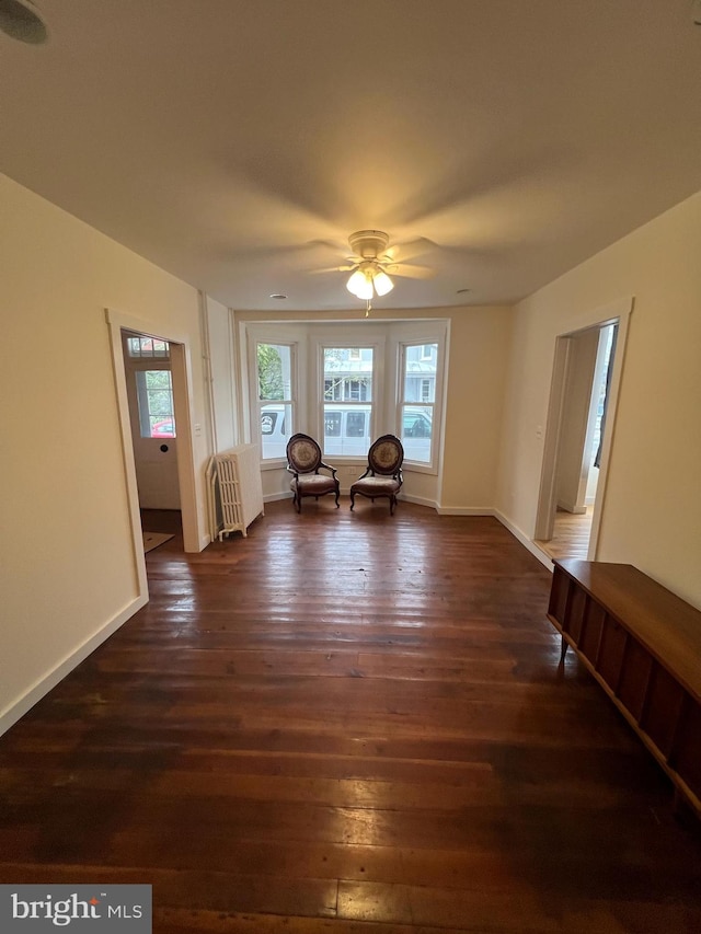 unfurnished room with dark hardwood / wood-style floors, radiator, and ceiling fan