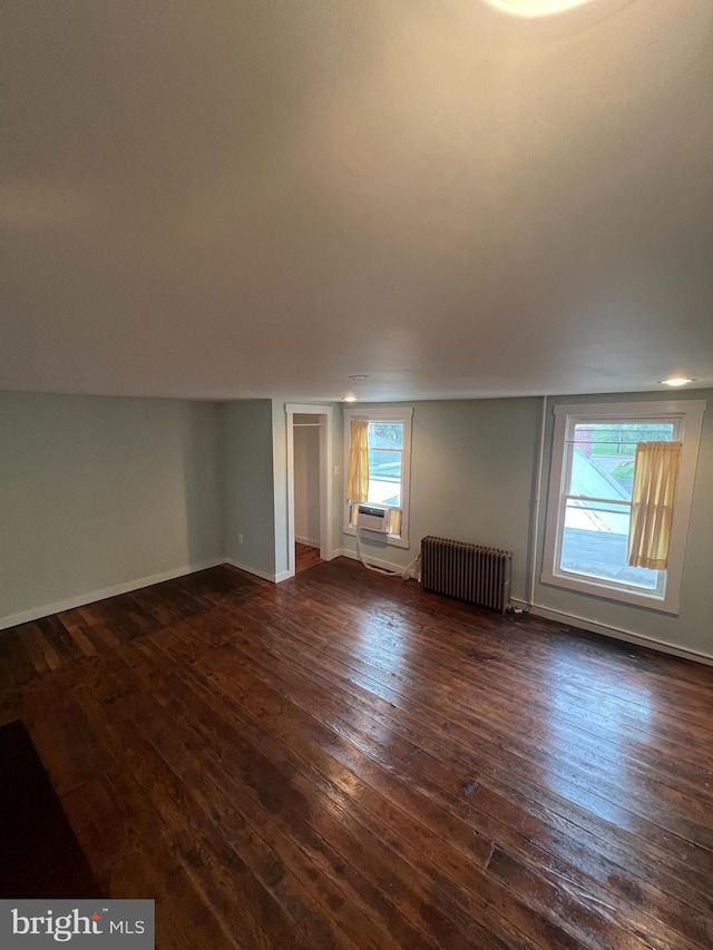 bonus room with a healthy amount of sunlight, lofted ceiling, radiator heating unit, and dark hardwood / wood-style floors