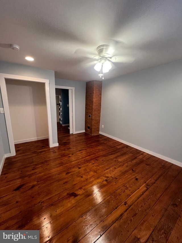 unfurnished bedroom featuring dark wood-type flooring, ceiling fan, and a closet