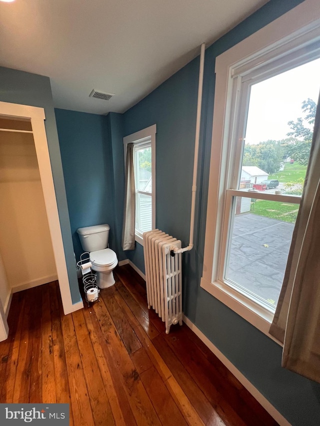 bathroom featuring toilet, wood-type flooring, and radiator