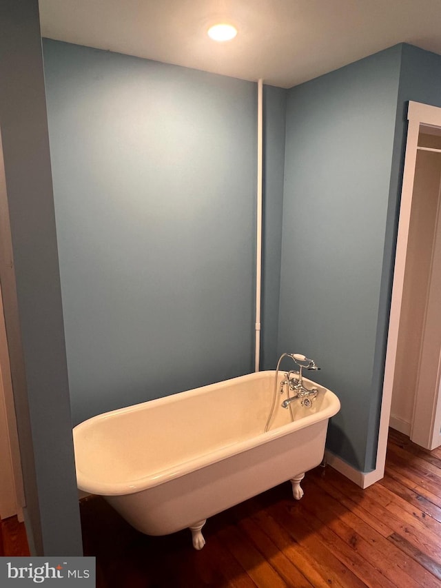 bathroom with a bathtub and wood-type flooring