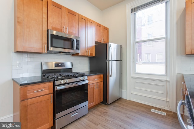 kitchen featuring light hardwood / wood-style flooring, stainless steel appliances, plenty of natural light, and tasteful backsplash