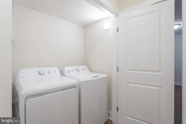 washroom with hardwood / wood-style floors and washing machine and dryer