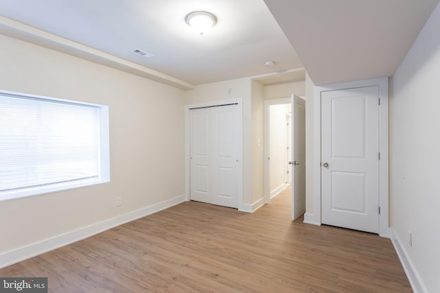 unfurnished bedroom featuring light hardwood / wood-style floors and a closet