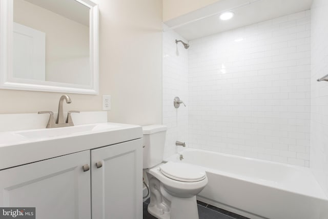 full bathroom featuring tile patterned floors, tiled shower / bath combo, vanity, and toilet