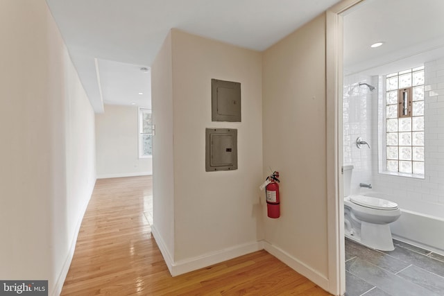 interior space featuring electric panel and light hardwood / wood-style flooring