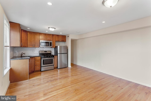 kitchen with light hardwood / wood-style flooring, a wealth of natural light, appliances with stainless steel finishes, and sink