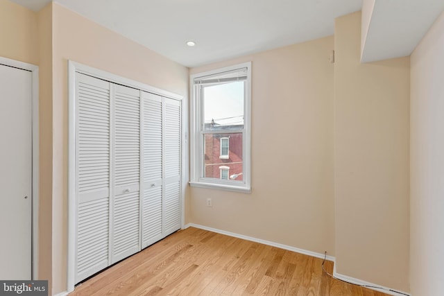 unfurnished bedroom featuring light wood-type flooring and a closet