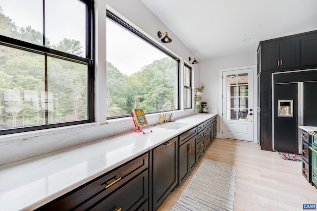 kitchen with light hardwood / wood-style floors, a healthy amount of sunlight, paneled built in refrigerator, and sink