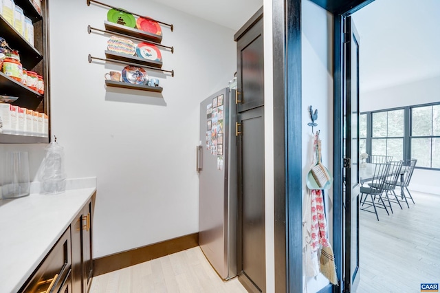 kitchen featuring light wood-type flooring and stainless steel fridge