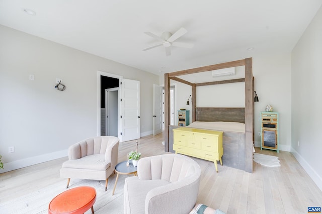 bedroom featuring ceiling fan, a wall mounted air conditioner, and light hardwood / wood-style flooring