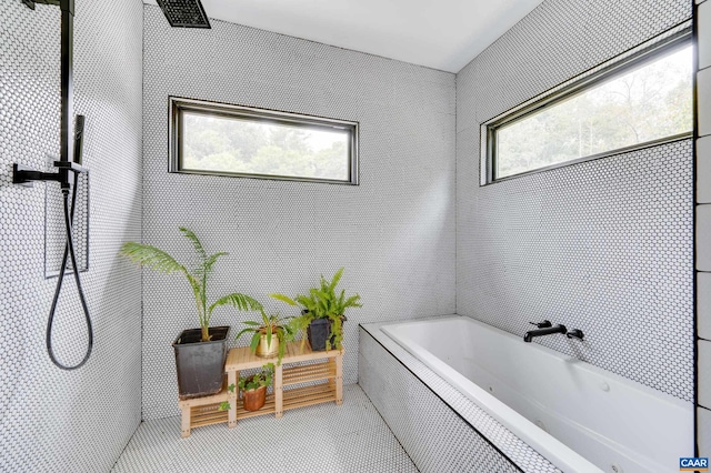 bathroom featuring tile patterned flooring and tiled bath