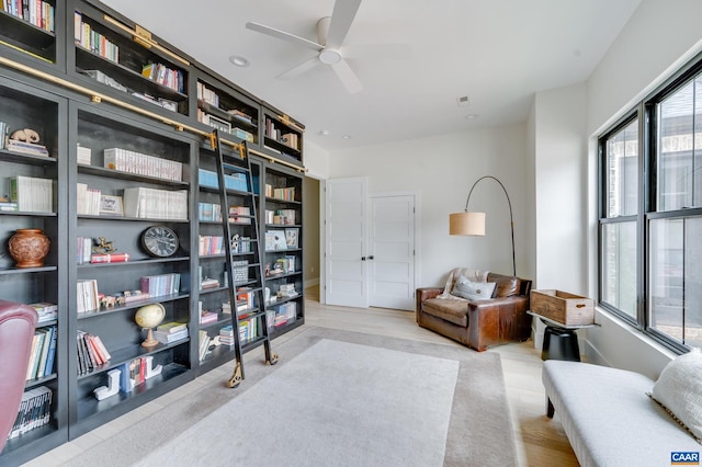 living area with light hardwood / wood-style flooring and ceiling fan