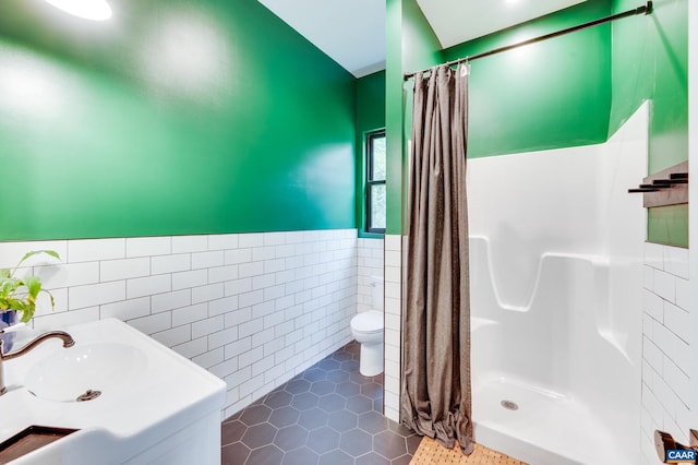 bathroom with tile walls, walk in shower, tile patterned floors, and toilet